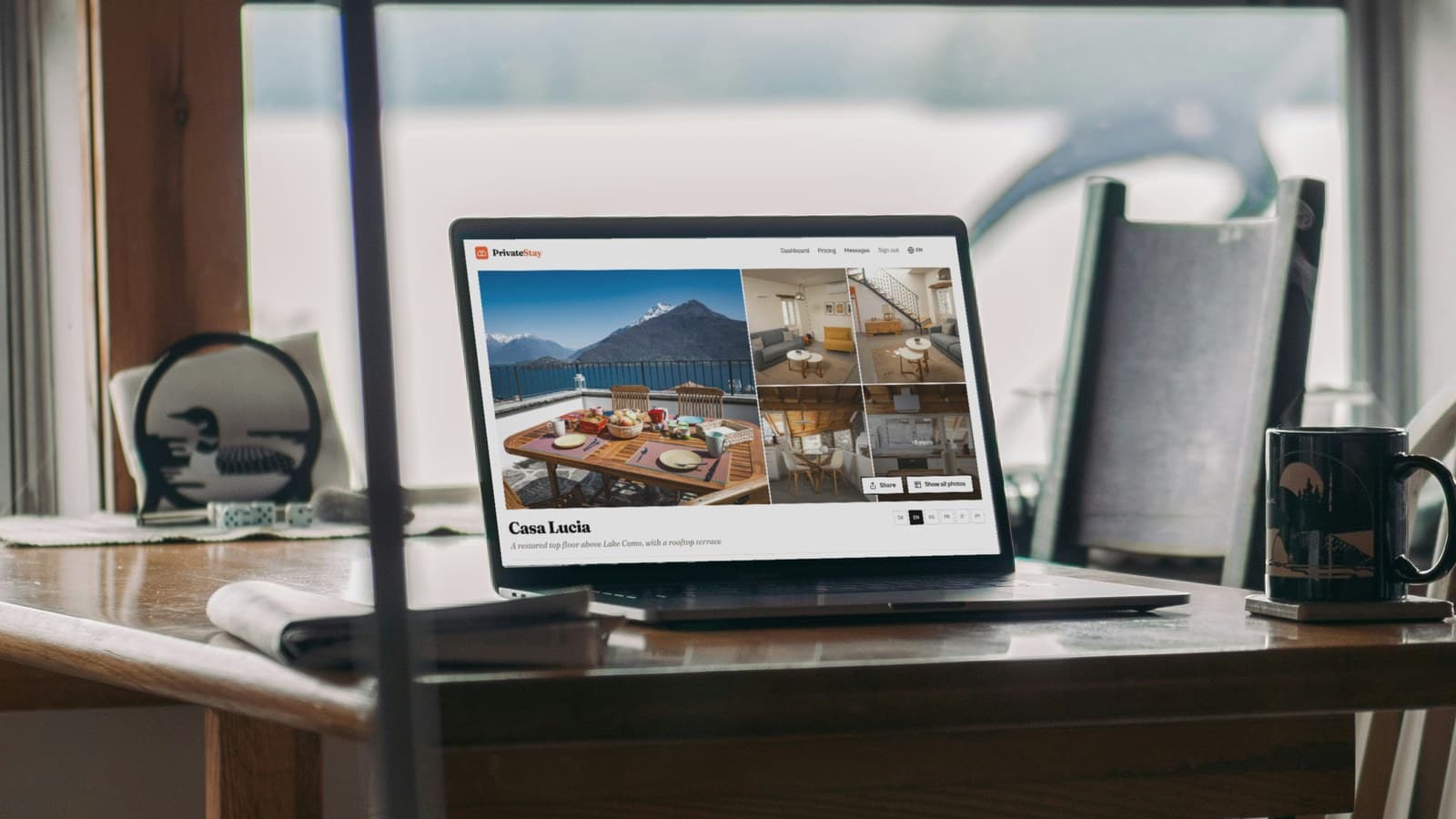 A laptop on a wooden table by a lakeside window, showing a private property page for an apartment on Lake Como